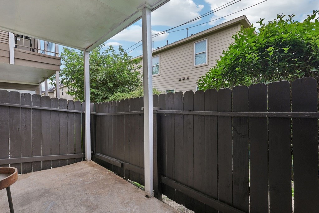 A patio with a black fence and a white awning.