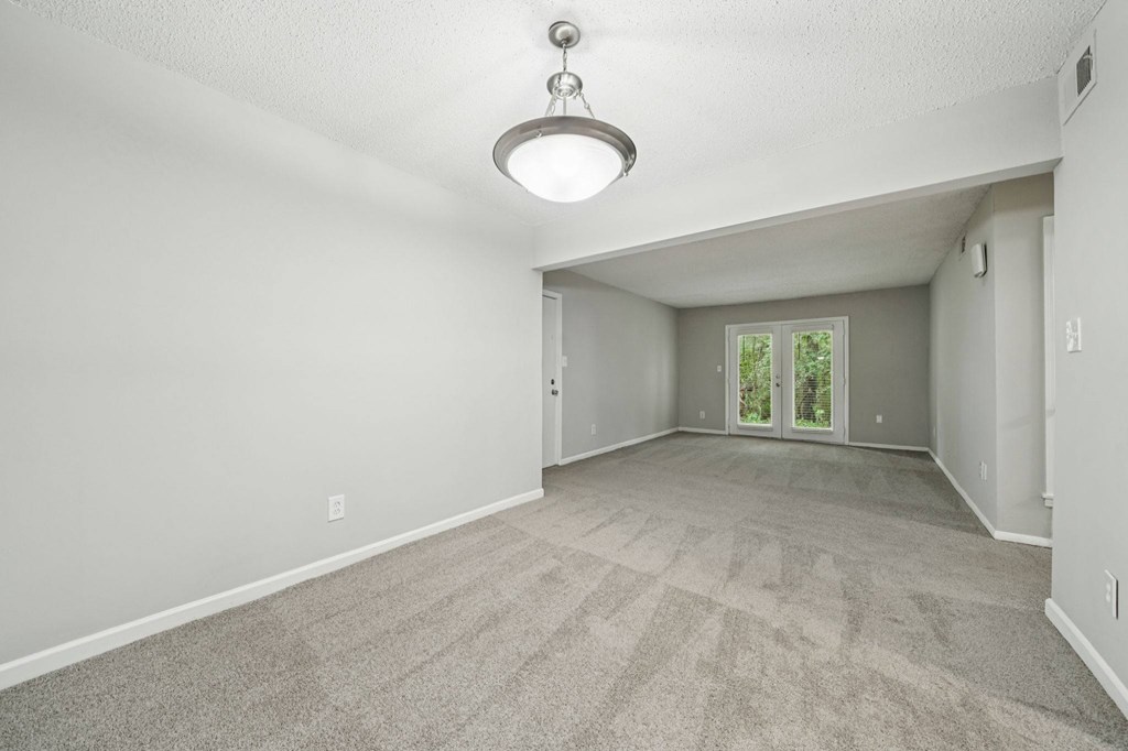A spacious room with a carpeted floor and a ceiling light.at Hills at Hoover Apartments, Hoover