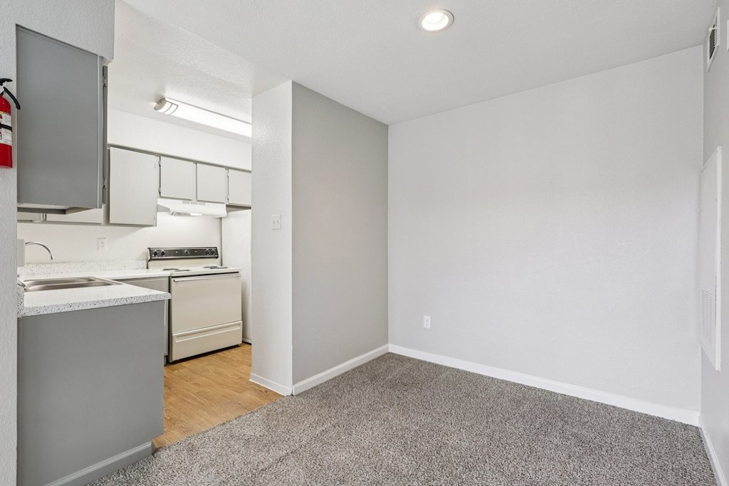 A small kitchen with white appliances and a white countertop.