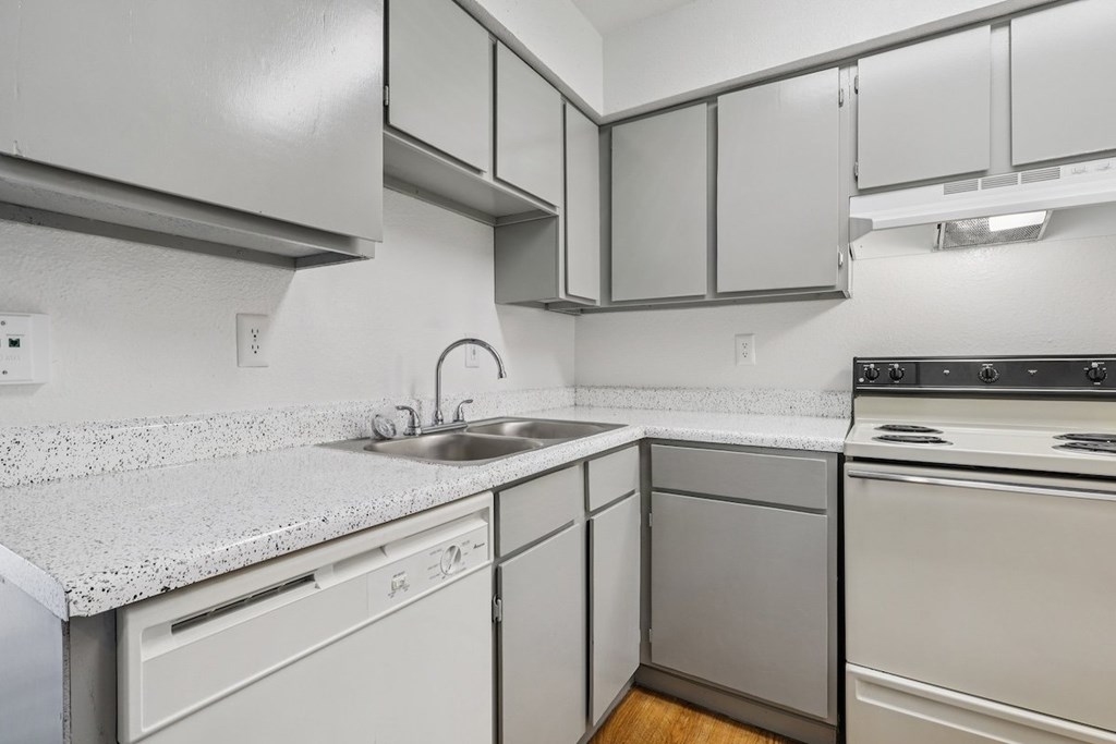 A kitchen with white appliances and cabinets.