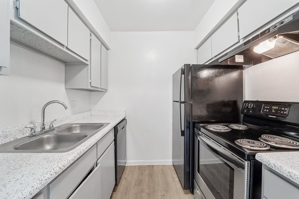 A modern kitchen with a black refrigerator and stove.
