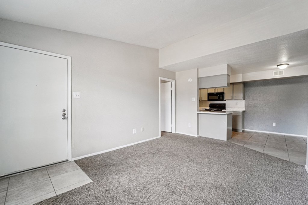 A room with a carpeted floor and a white door.