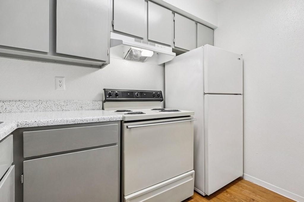 A kitchen with a white refrigerator and a stove top oven.
