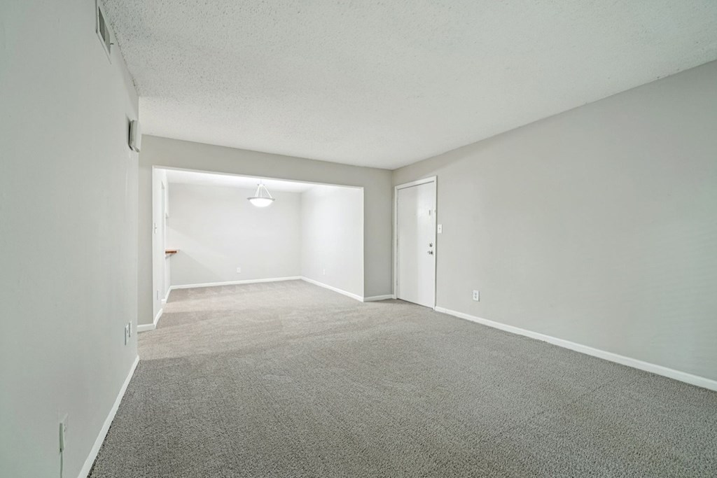 A spacious room with carpeted floor and white walls.at Hills at Hoover Apartments, Alabama