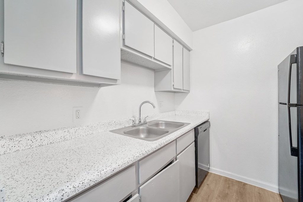 A kitchen with white cabinets and a granite countertop.