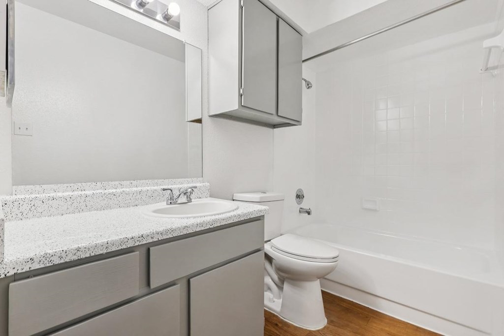 A white bathroom with a toilet, sink, and bathtub.