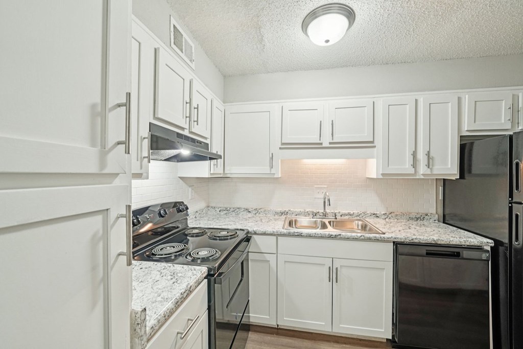 A kitchen with white cabinets and a granite countertop.at Hills at Hoover Apartments, Hoover