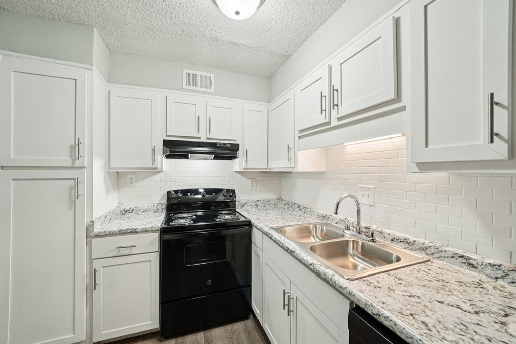 A kitchen with white cabinets and a black stove top oven.at Hills at Hoover Apartments, Hoover, AL 35216
