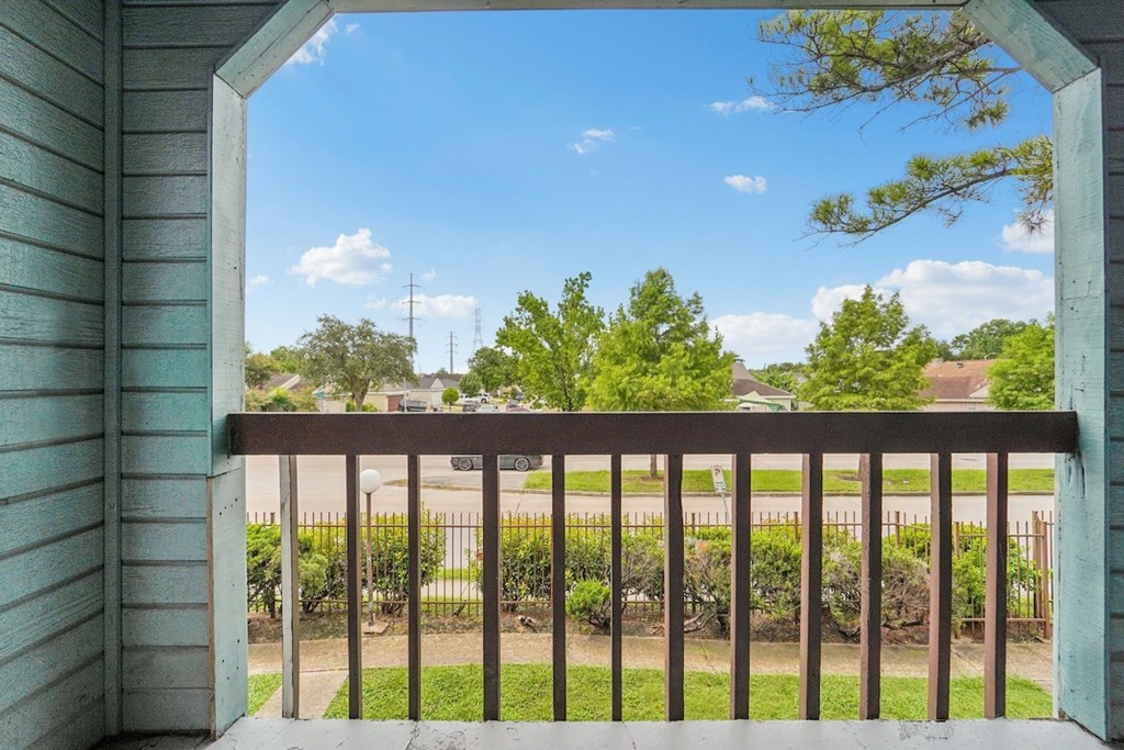 A view from a balcony looking out at a residential neighborhood.