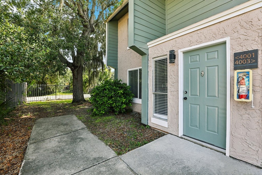 A green house with a blue door and a sign on the wall.