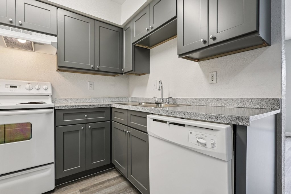A kitchen with a white oven and a dishwasher.