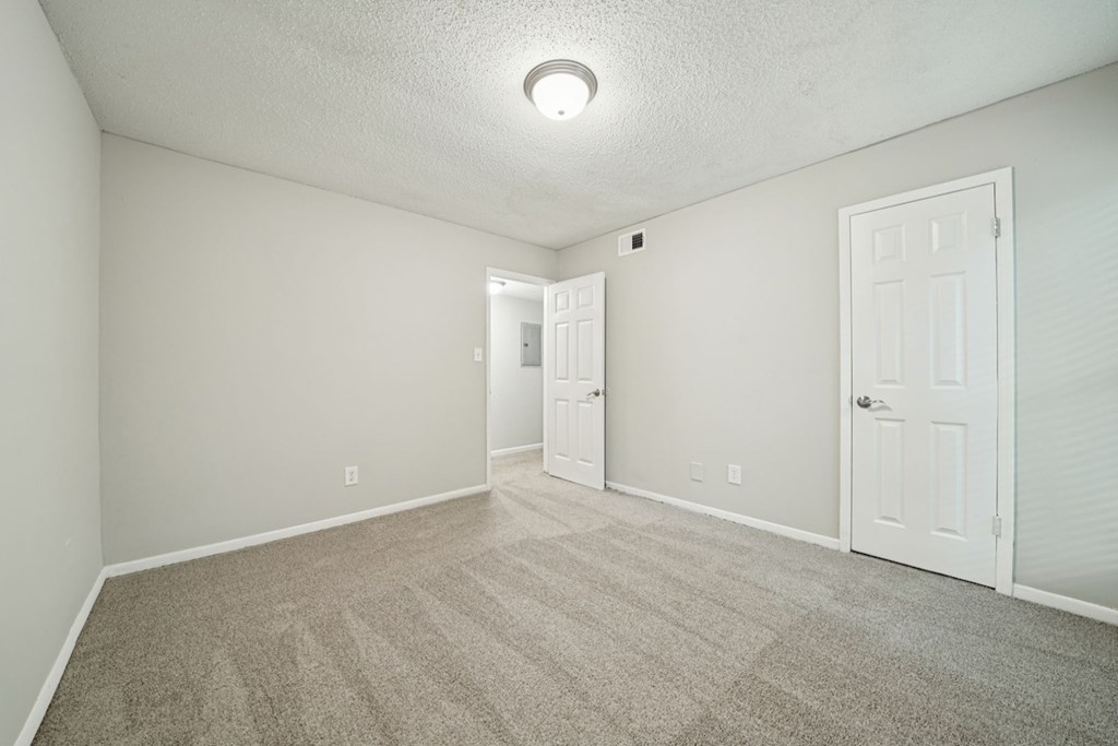 A room with carpeted floor and two doors.at Hills at Hoover Apartments, Alabama, 35216