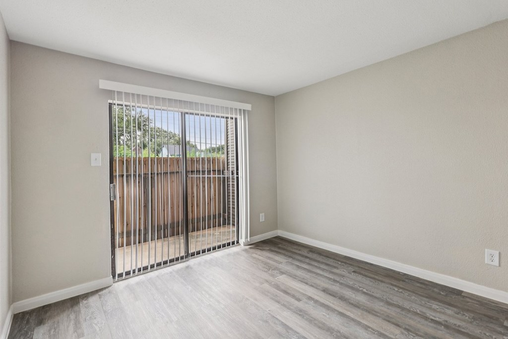A room with a sliding door leading to a backyard.