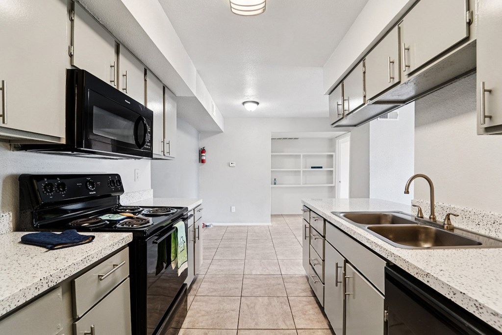 A kitchen with black appliances and white cabinets.