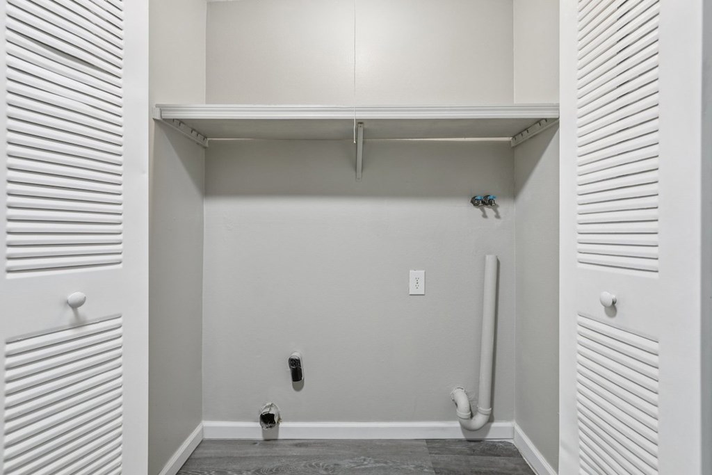 A white bathroom with a toilet and a pipe.