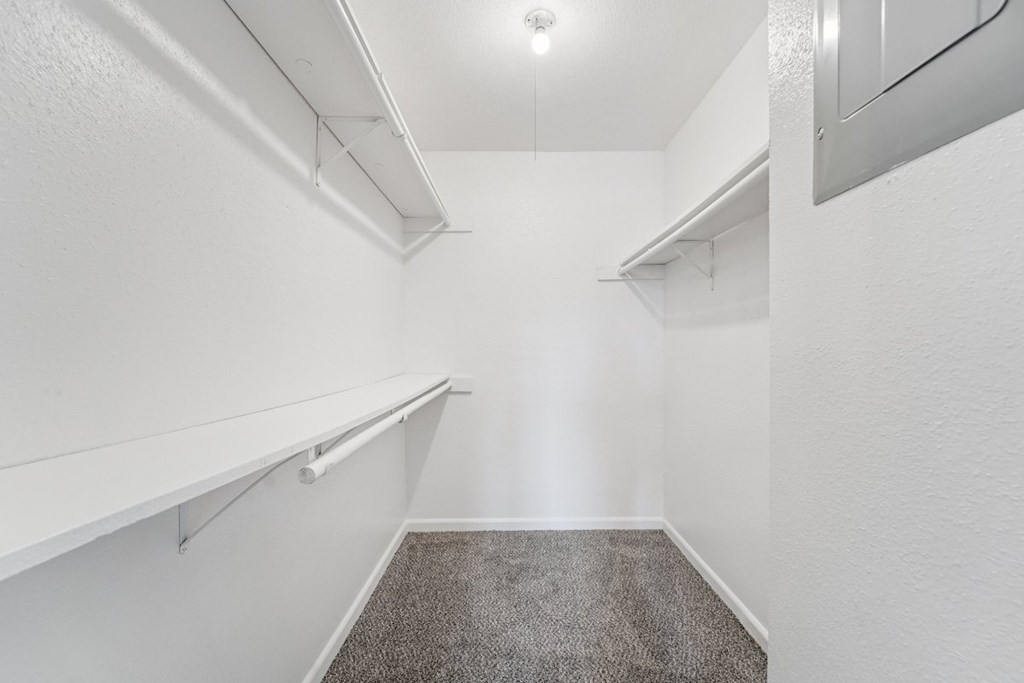 A white hallway with a carpeted floor and white walls.