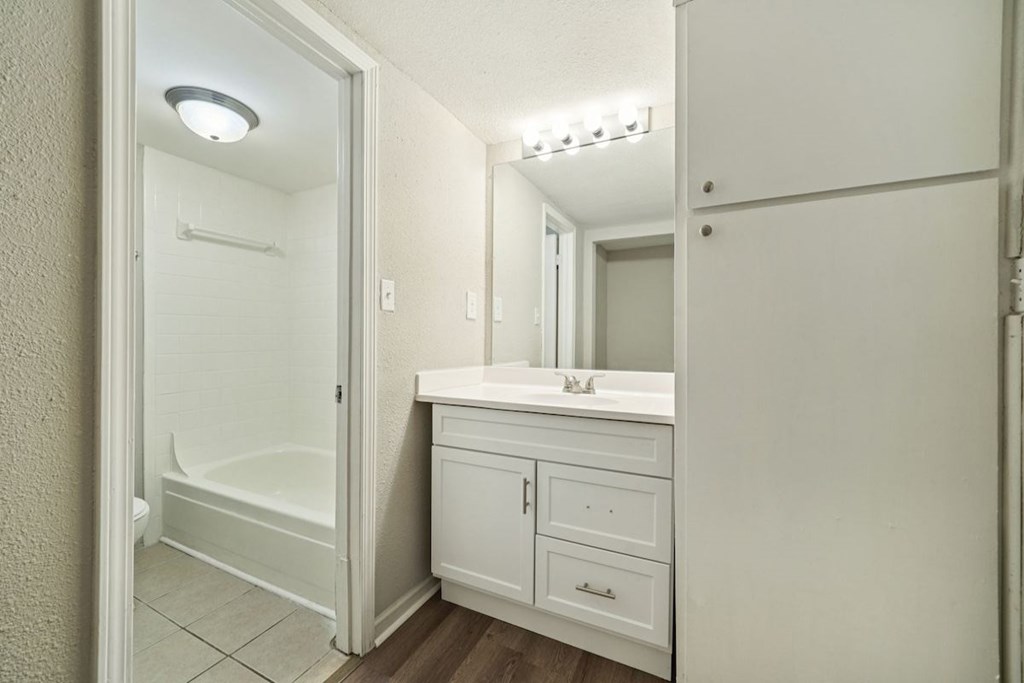 A white bathroom with a vanity and a walk-in shower.at Hills at Hoover Apartments, Hoover Alabama