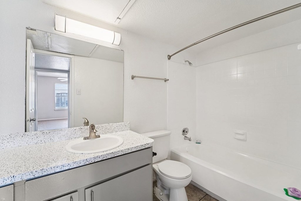 A white bathroom with a toilet, sink, and bathtub.