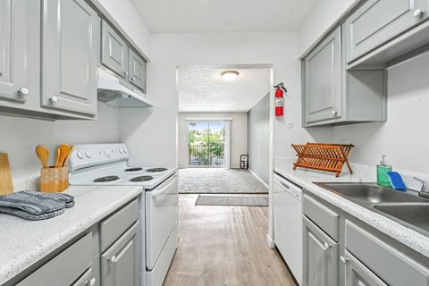 A kitchen with white cabinets and a white stove top oven.