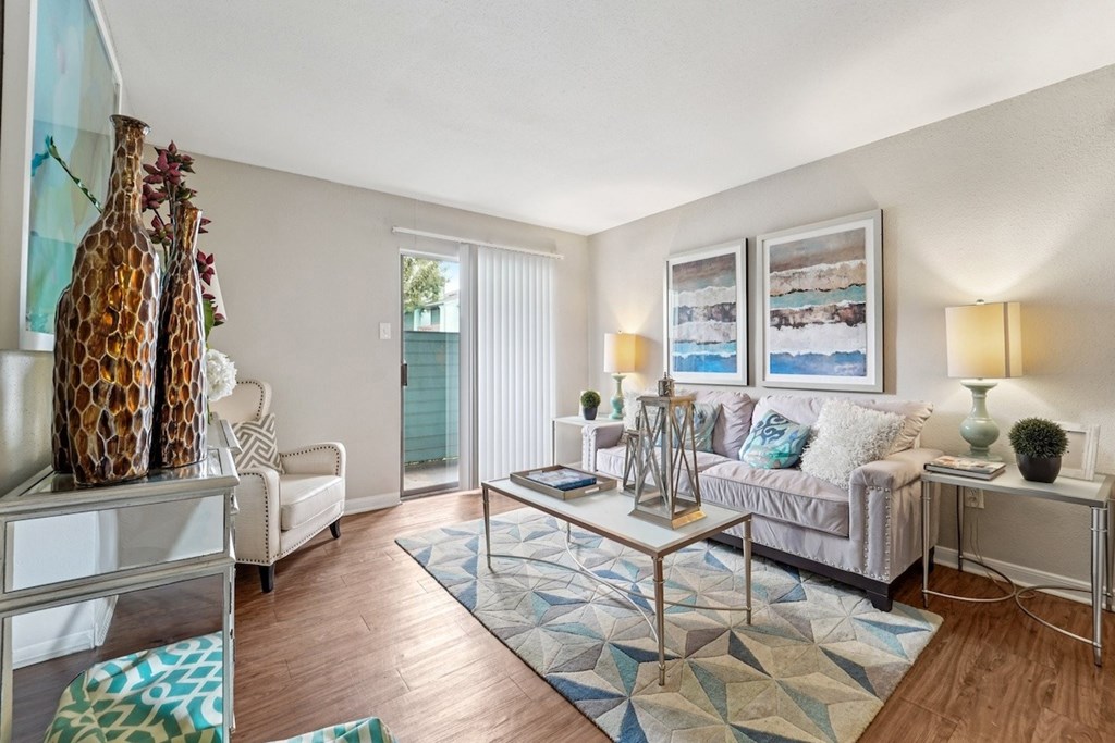 A living room with a sofa, a coffee table, and a painting on the wall.