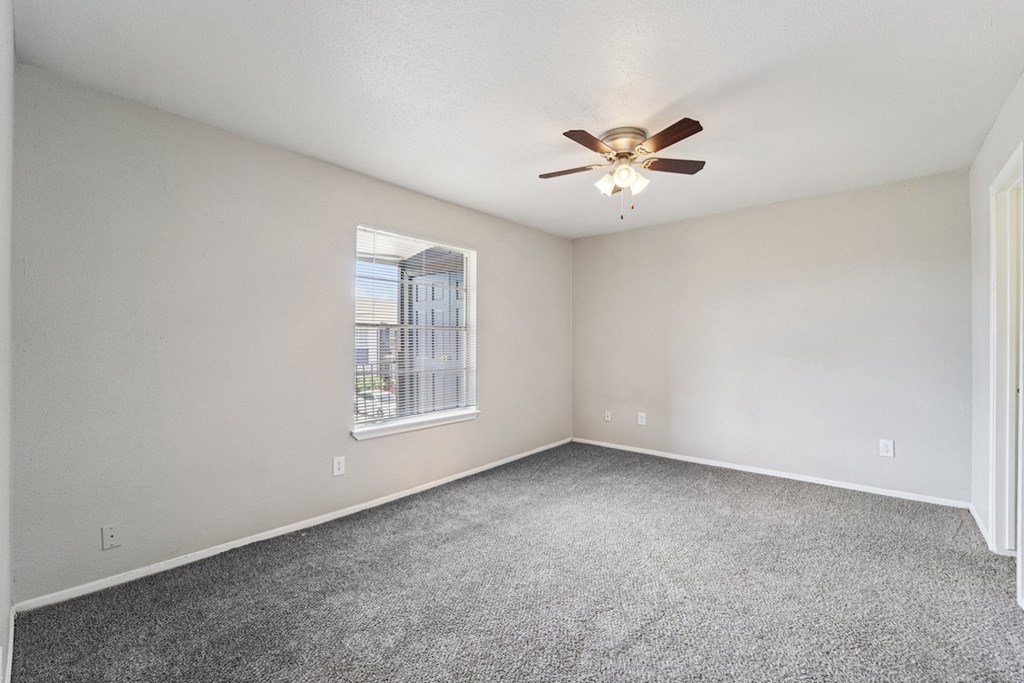 A room with a ceiling fan and a window.