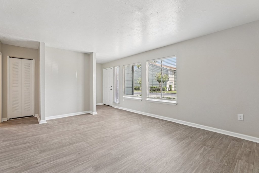 A room with a door and a window with a view of a building outside.