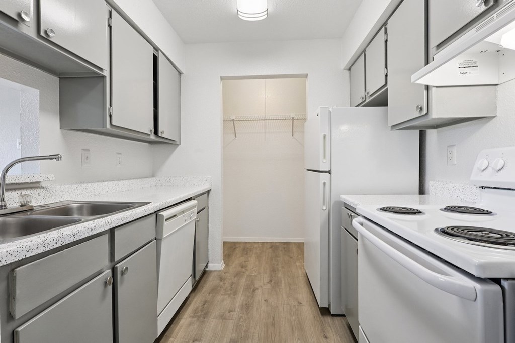 A kitchen with white appliances and cabinets.