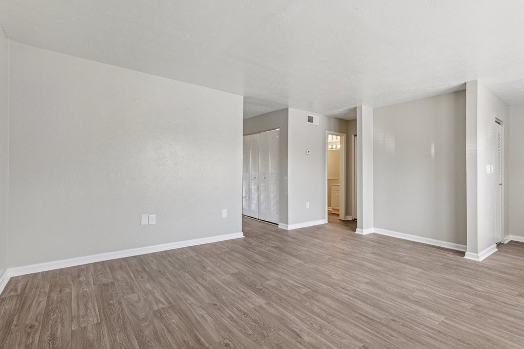 A room with wooden flooring and white walls.