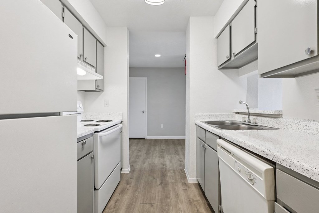 A kitchen with white appliances and cabinets.