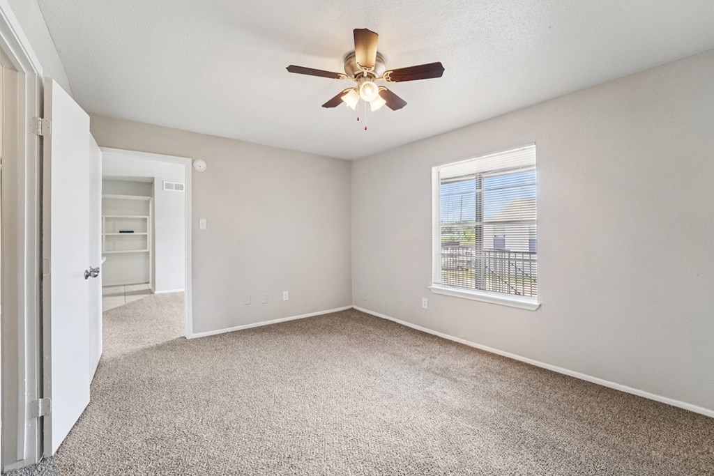 A room with a ceiling fan and a window.
