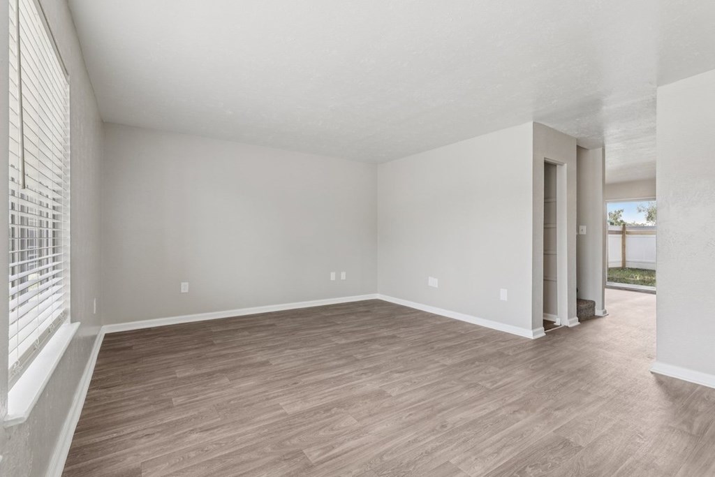 A room with wooden flooring and white walls.