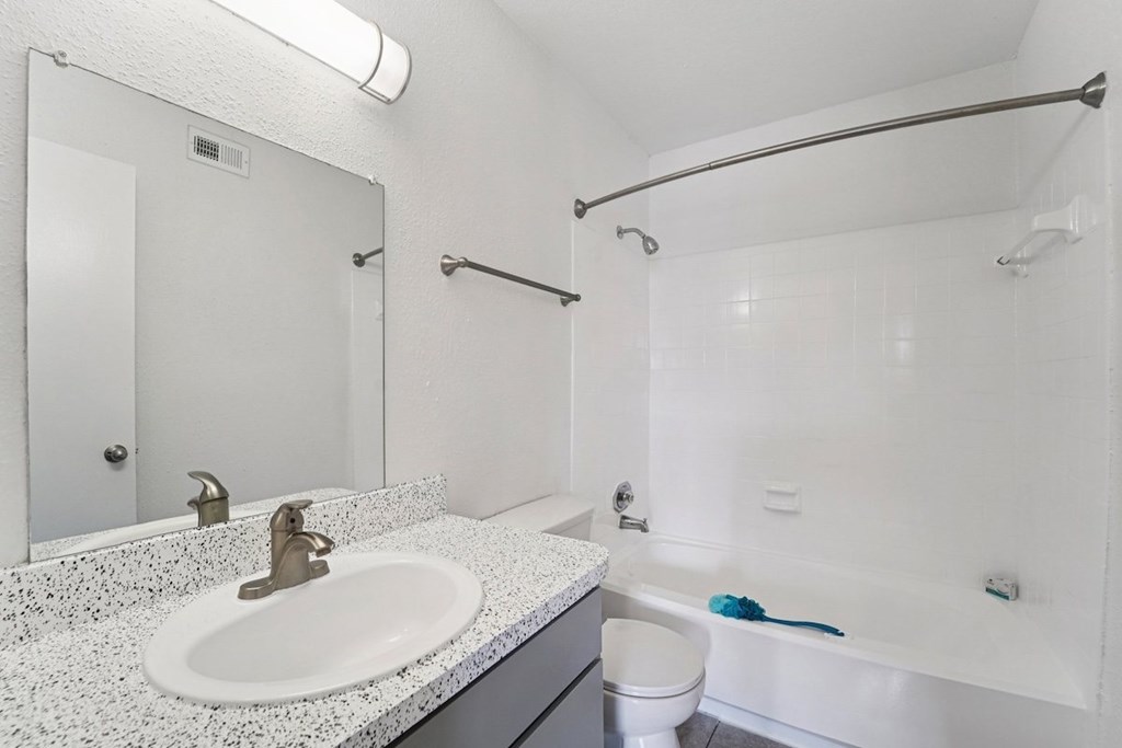 A white bathroom with a sink, toilet, and bathtub.