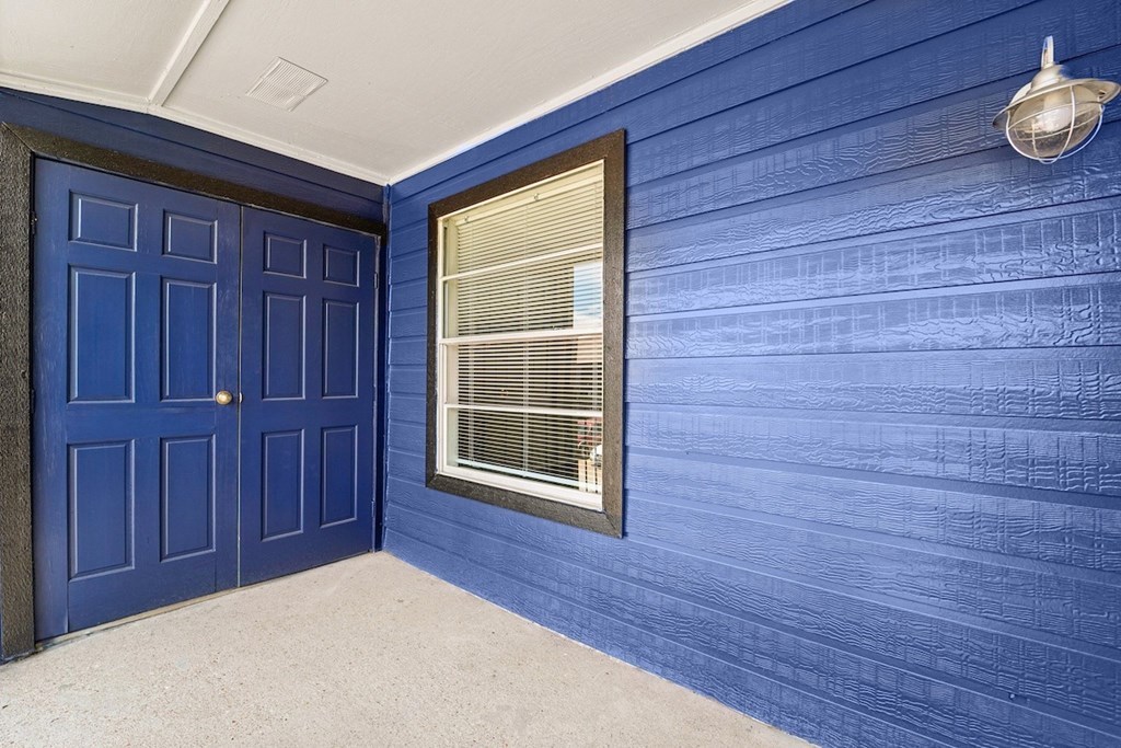 A room with blue walls and a window with blinds.