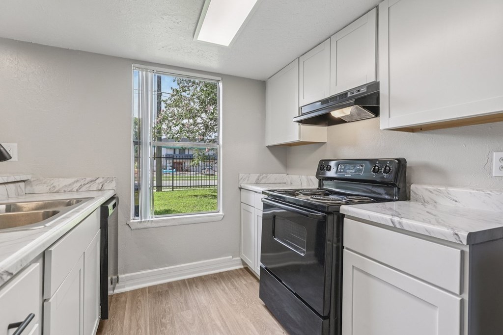 A kitchen with white cabinets and a black oven.