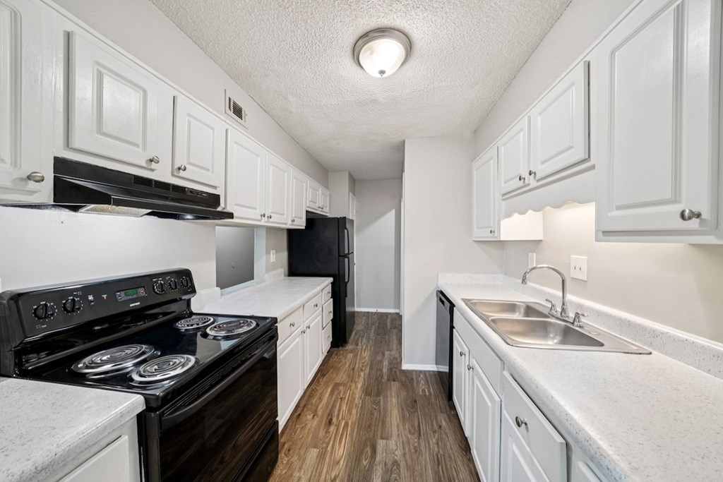 A kitchen with white cabinets and a black stove top oven.at Hills at Hoover Apartments, Hoover Alabama