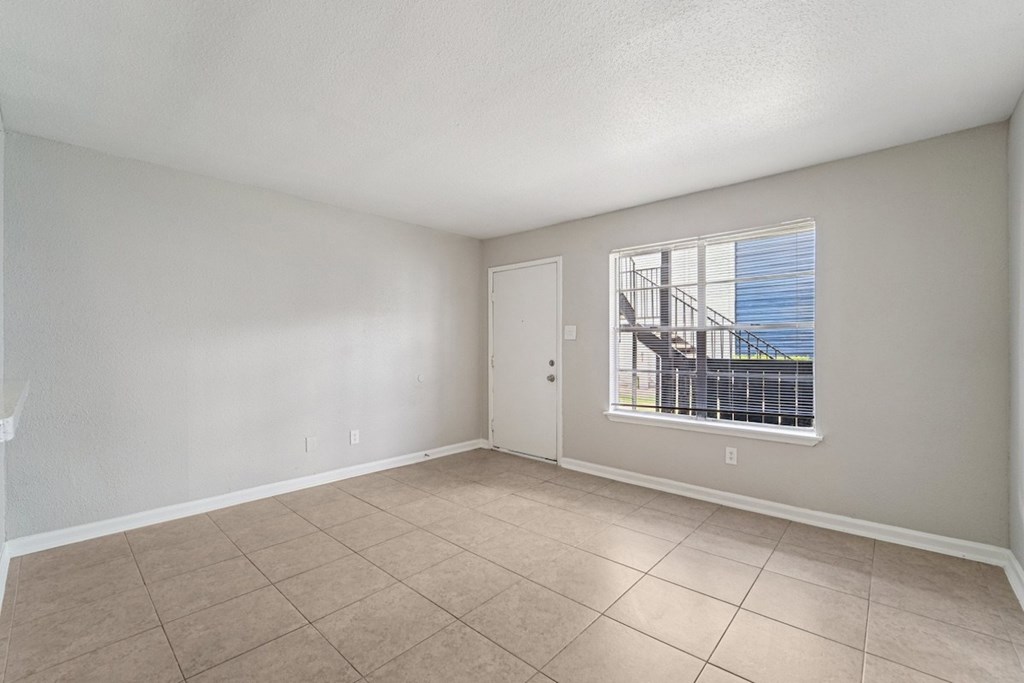 A room with a window overlooking a balcony.