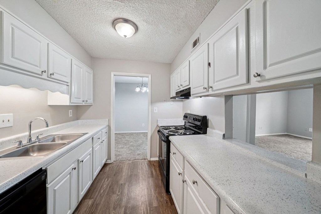 A kitchen with white cabinets and a black dishwasher.at Hills at Hoover Apartments, Hoover