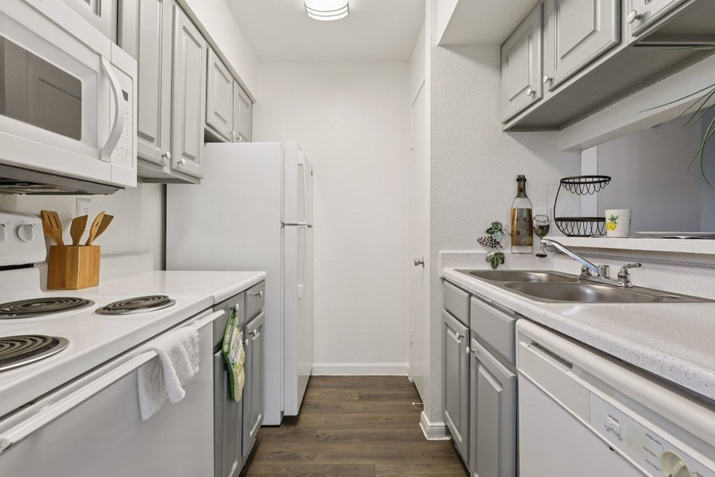 A kitchen with white appliances and a white counter top.