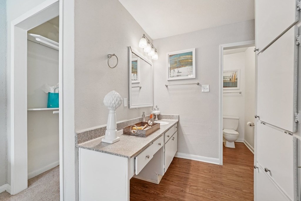 A small white bathroom with a sink, toilet, and a mirror.