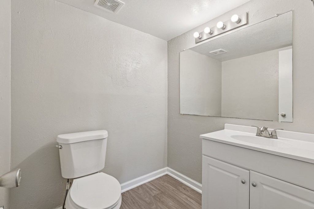 A white toilet sits next to a white sink in a small bathroom.