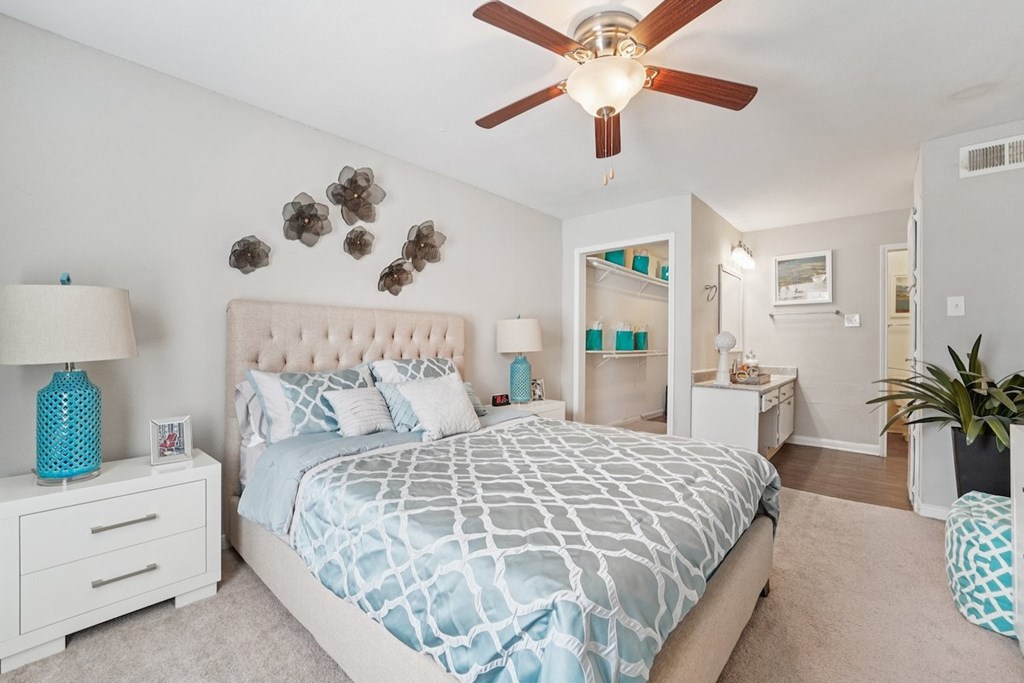 A bedroom with a large bed and a ceiling fan.