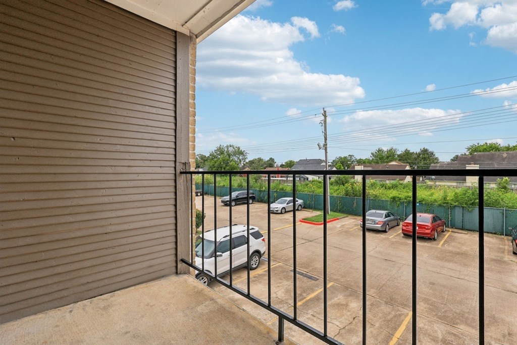 A parking lot with cars and a closed gate.