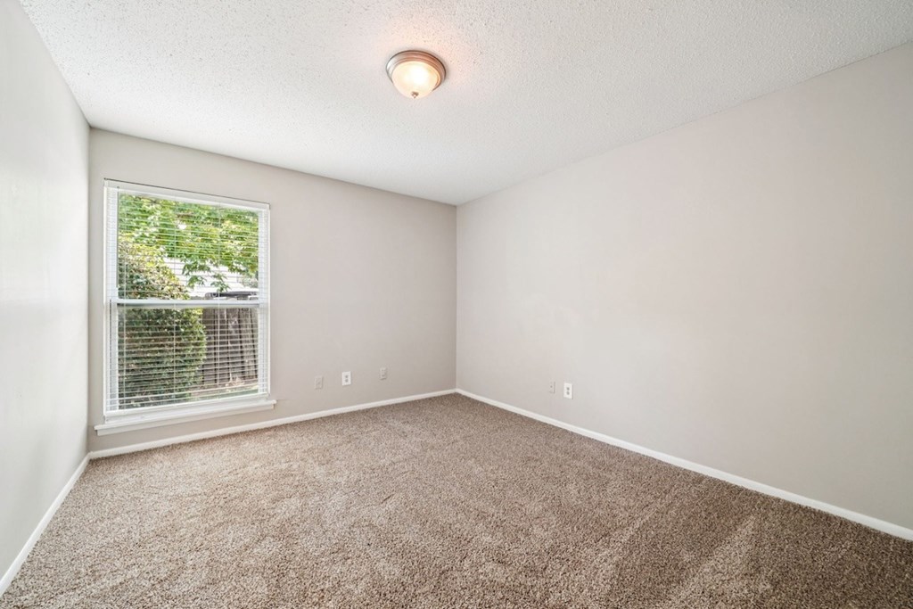 A room with a window and a carpeted floor.at Hills at Hoover Apartments, Alabama, 35216