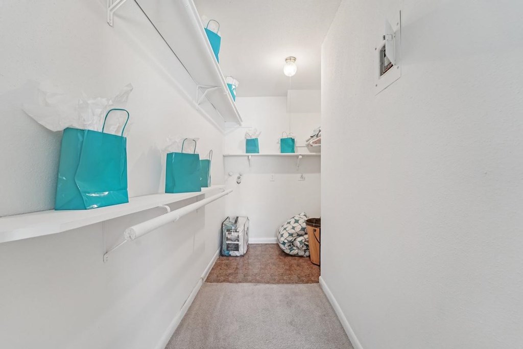 A hallway with white walls and a brown carpet.