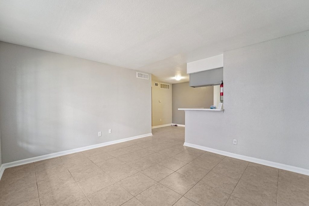 A room with a white ceiling and beige tiled floor.