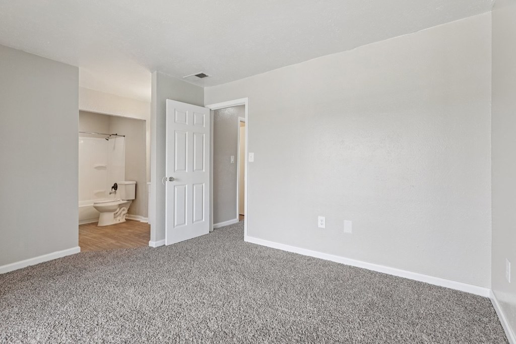 A room with a carpeted floor and a toilet in the corner.