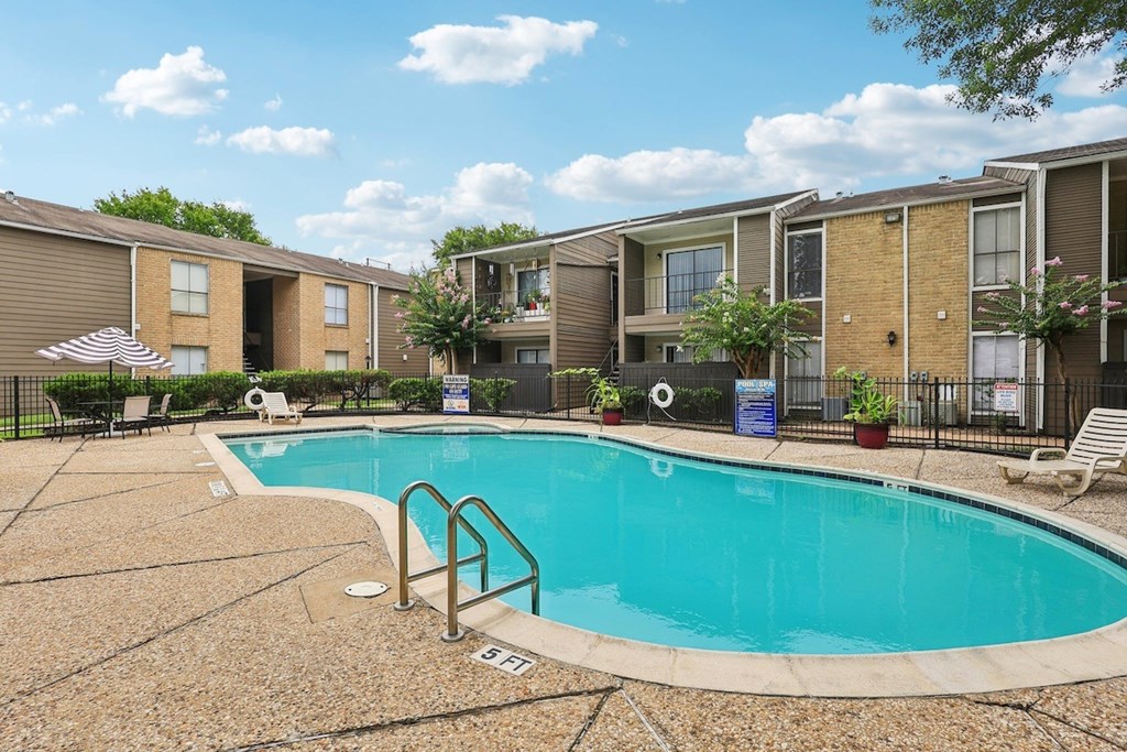 A swimming pool surrounded by apartment buildings.