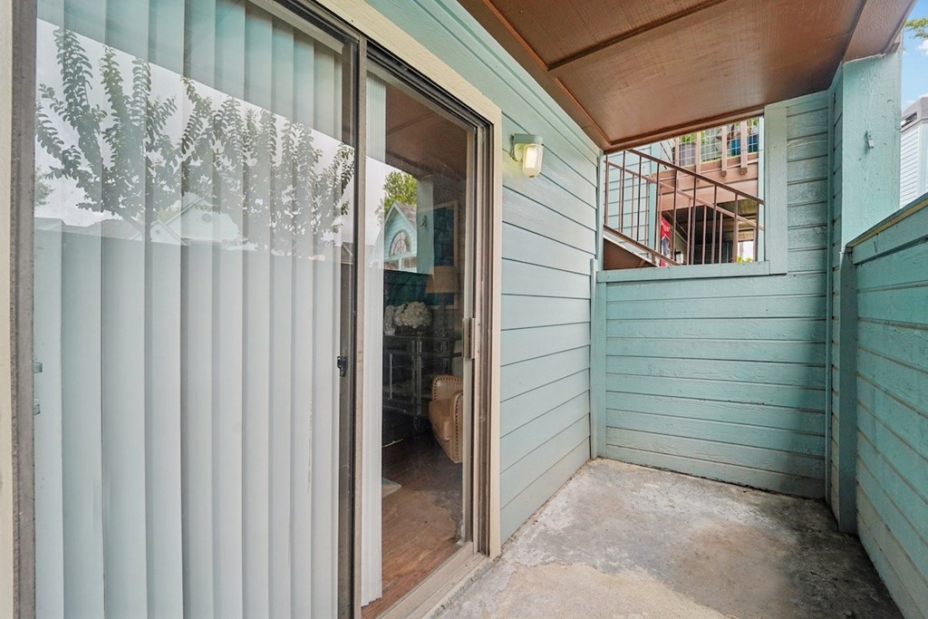 A room with a sliding glass door leading to a balcony.