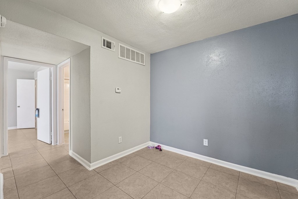 A room with a white door and a grey wall.