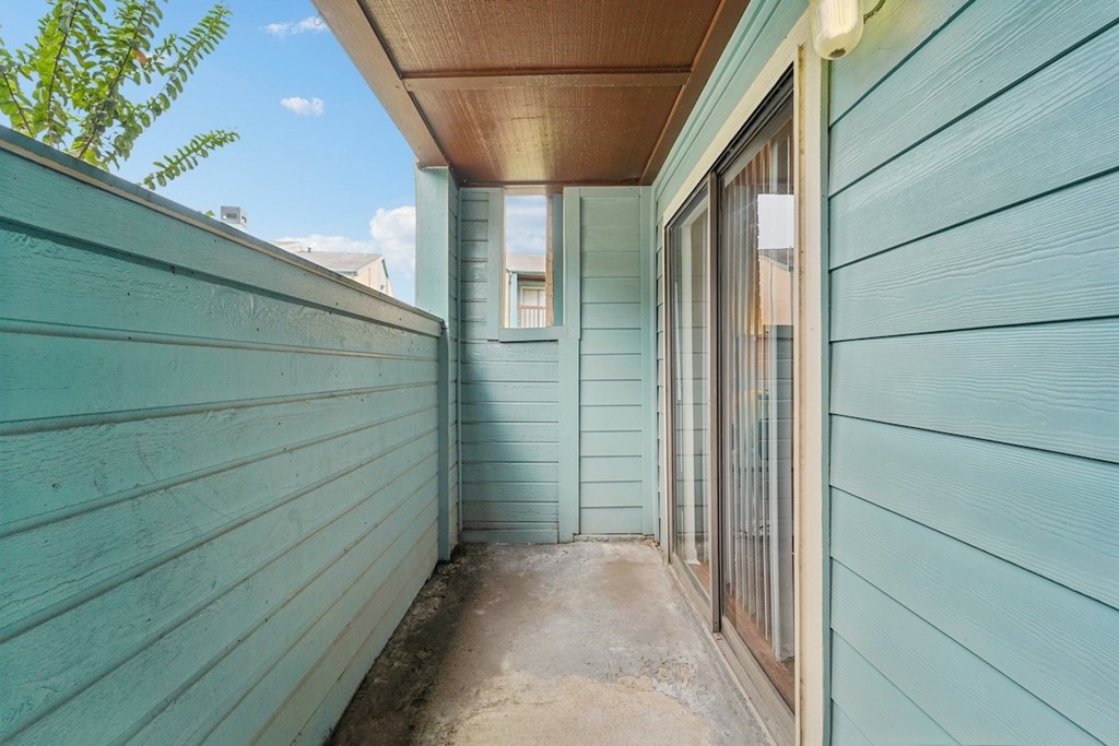 A narrow alley with a wooden ceiling and a door with a glass window.